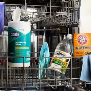 open dishwasher with cleaning supplies inside
