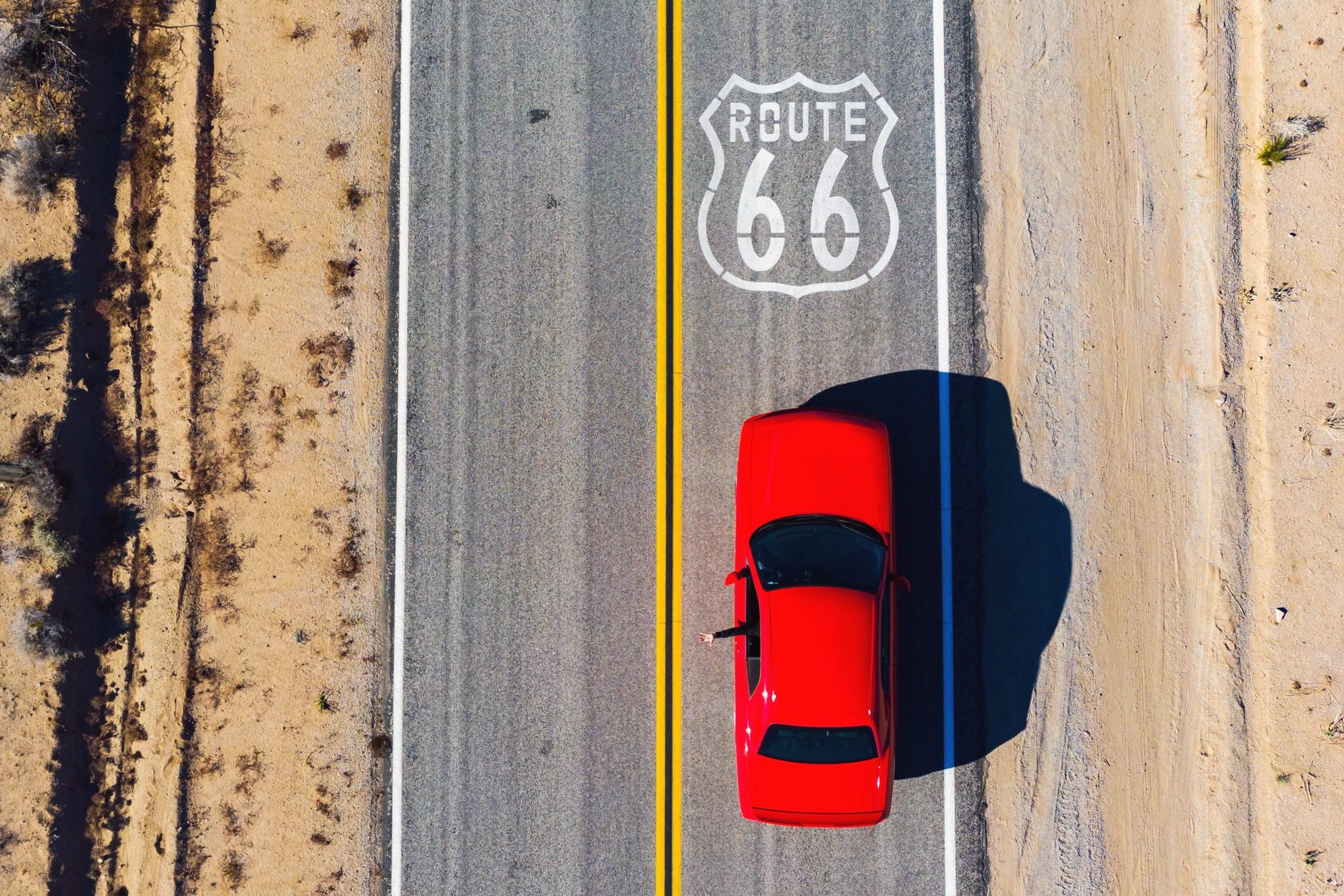 Drone view of American car driving in a straight road of the famous Route 66.
