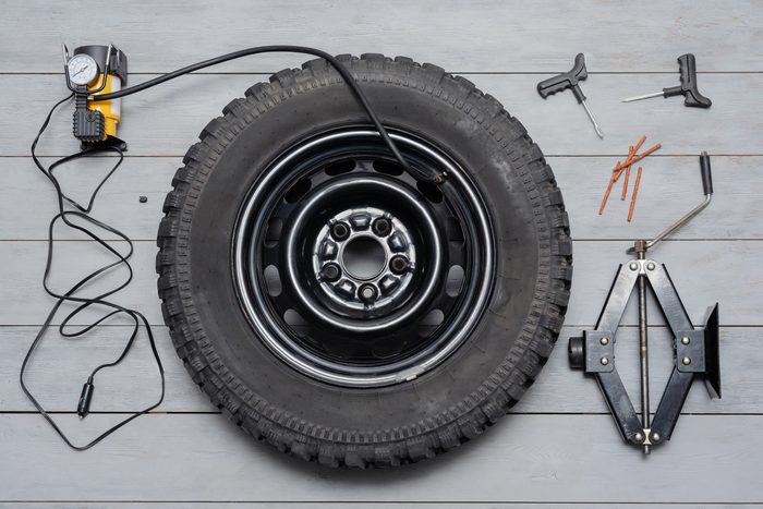 Tire and accessories on a gray wood background, top view