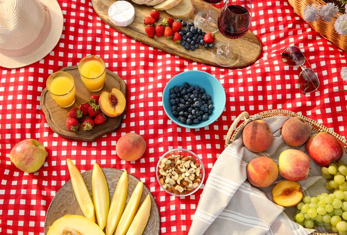 Delicious food and drinks on picnic blanket, above view